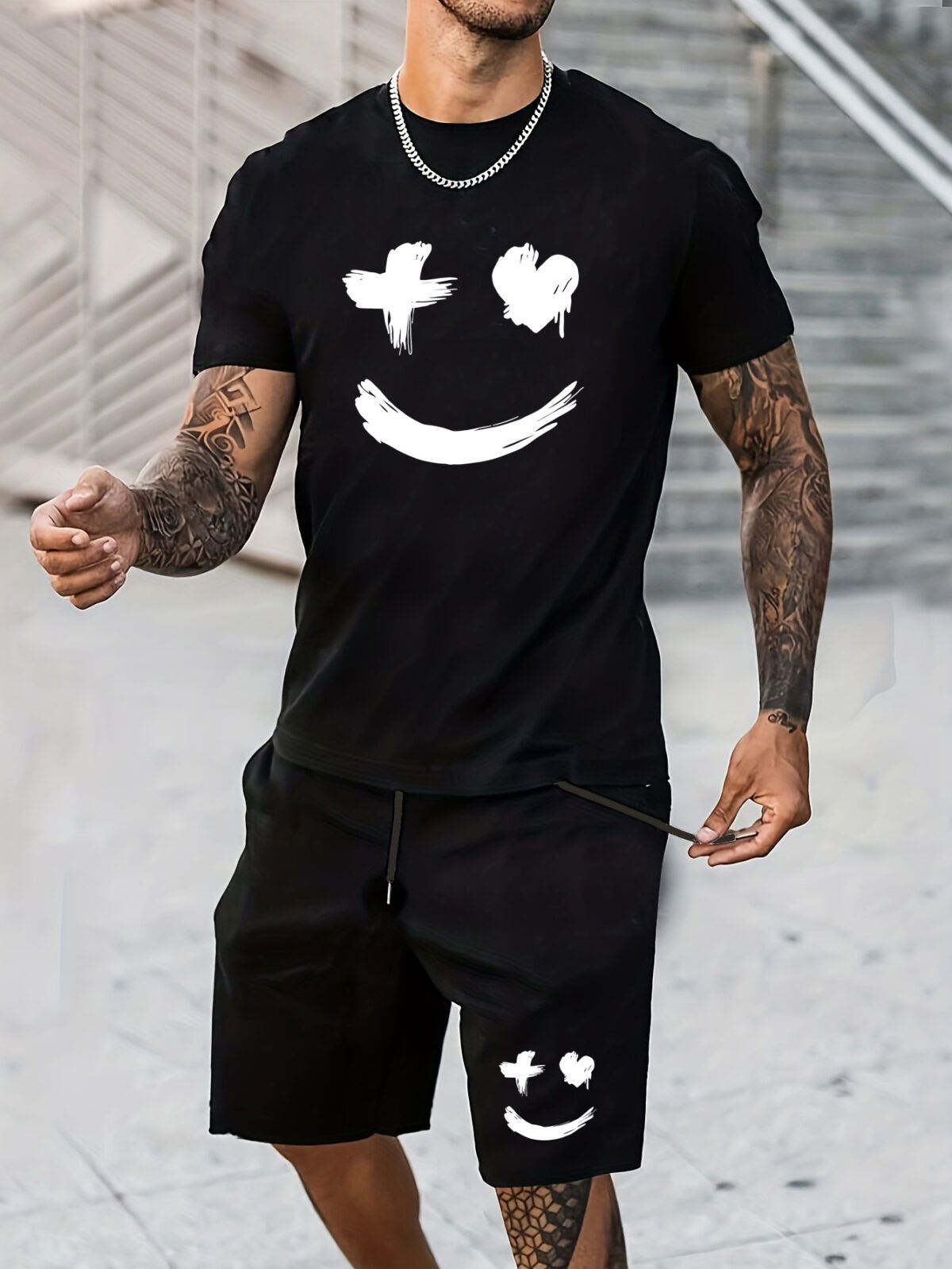 Model wearing the Newness Urban Edge Smiley Face Shorts Set a trendy mens outfit featuring a stylish smiley face graphic and comfortable modern fit perfect for vacation or workouts
