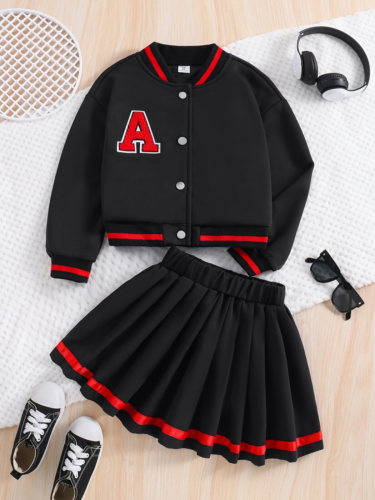 Stylish preppy varsity jacket and skirt set in navy and cream modeled on a student in a school setting