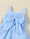 Adorable little girl wearing a stylish navy and white striped summer dress perfect for playdates and picnics She is smiling and looks happy