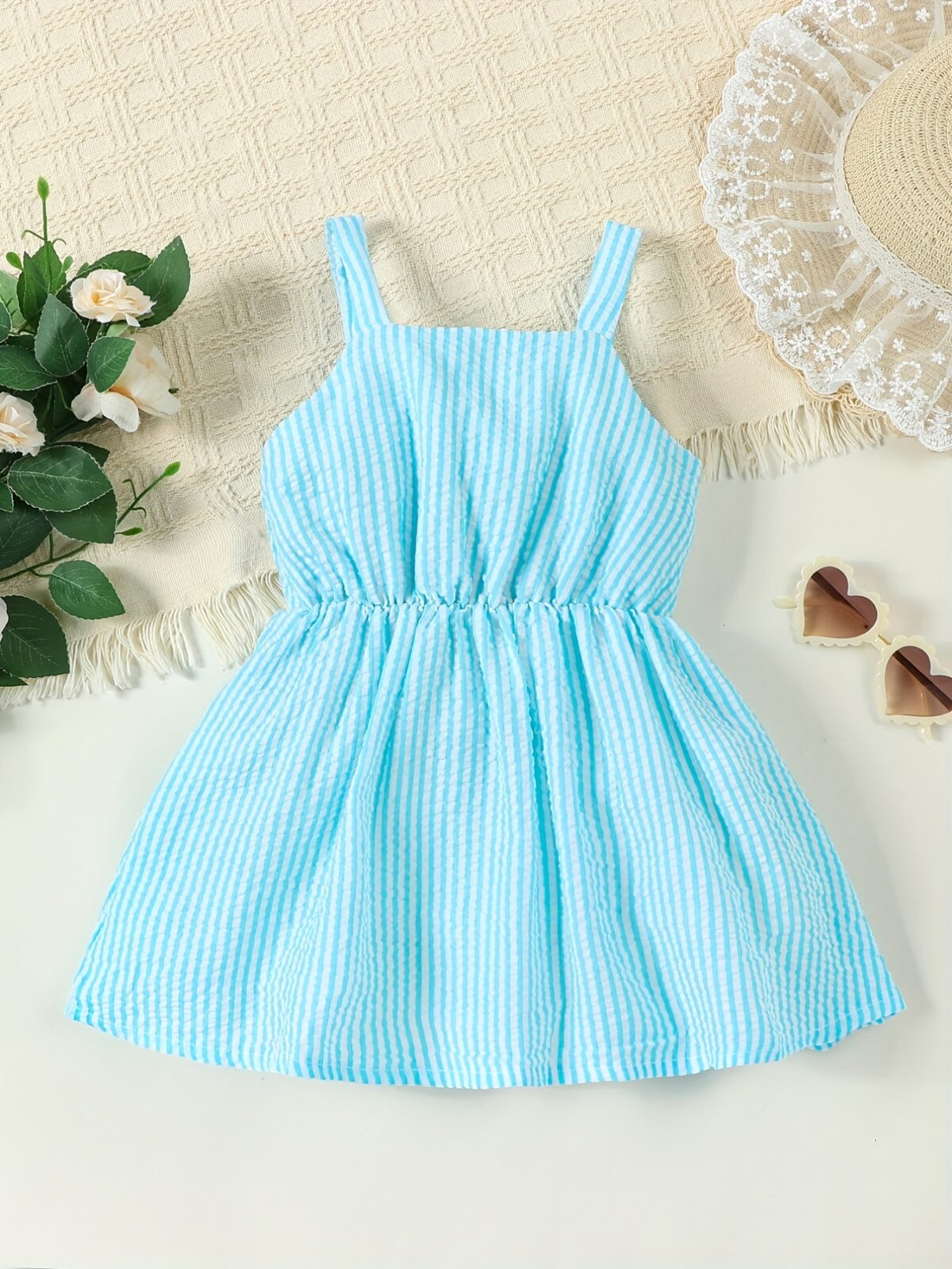Adorable little girl wearing a stylish navy and white striped summer dress perfect for playdates and picnics She is smiling and looks happy