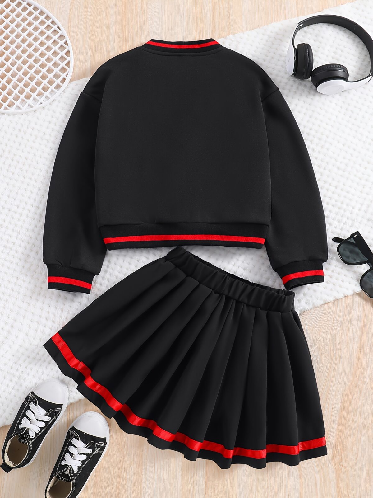 Stylish preppy varsity jacket and skirt set in navy and cream modeled on a student in a school setting
