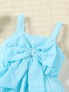 Adorable little girl wearing a stylish navy and white striped summer dress perfect for playdates and picnics She is smiling and looks happy