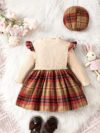 Adorable girl wearing a red and white plaid dress and matching beret Perfect for spring or fall