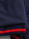 Stylish preppy varsity jacket and skirt set in navy and cream modeled on a student in a school setting