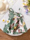 Baby girl wearing adorable Island Bloom floral print dress smiling
