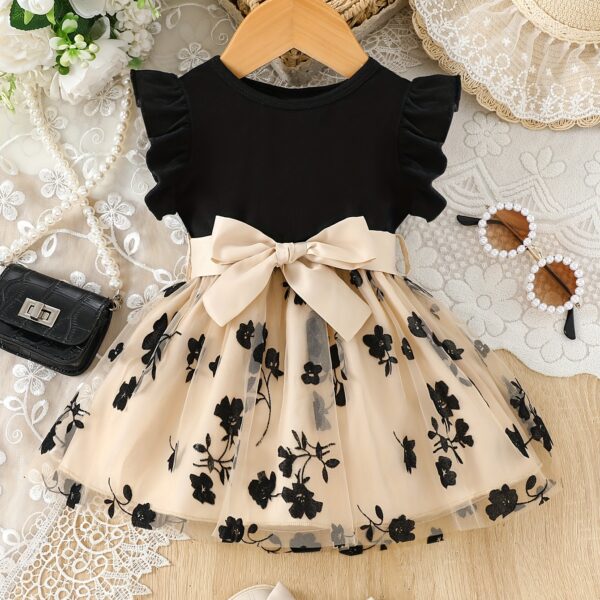 Adorable little girl twirling in a beautiful summer floral mesh dress from Newness The dress is lightweight and perfect for warm weather