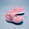Adorable toddler wearing Newnesss Summer Breeze Sneakers running playfully outdoors on a sunny day