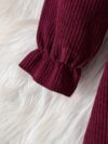 Adorable baby girl wearing a charming corduroy dress perfect for playtime or special occasions