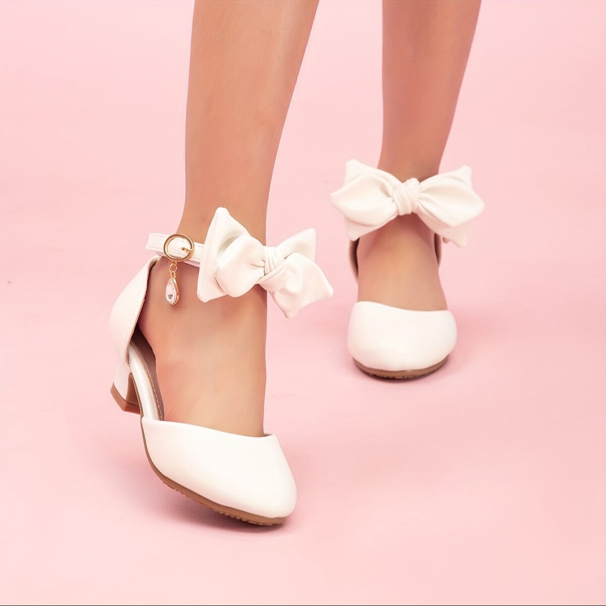 Enchanted Bow Girls White Heels by Newness Stylish and comfortable white heels with a charming bow detail perfect for any occasion