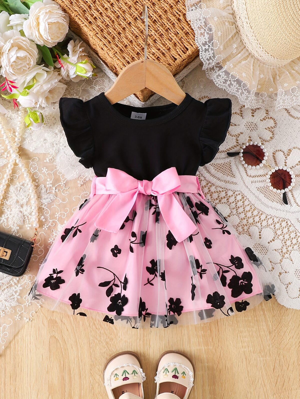Adorable little girl twirling in a beautiful summer floral mesh dress from Newness The dress is lightweight and perfect for warm weather
