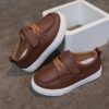 Close up of stylish brown leather boys loafers showcasing the stitching and buckle detail