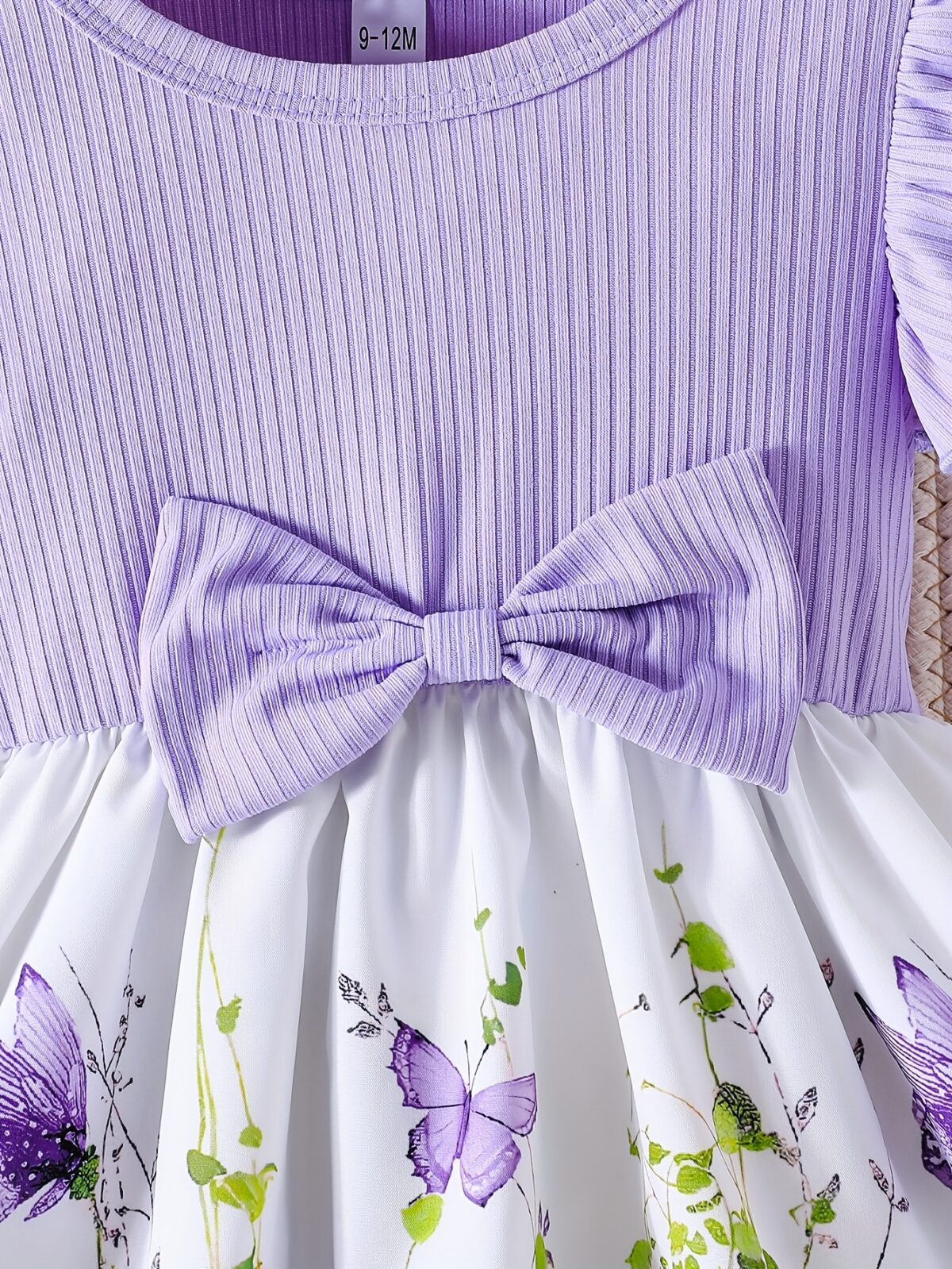 Adorable baby girl wearing a charming butterfly print dress from Newness perfect for spring and summer