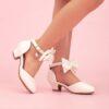 Enchanted Bow Girls White Heels by Newness Stylish and comfortable white heels with a charming bow detail perfect for any occasion
