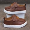Close up of stylish brown leather boys loafers showcasing the stitching and buckle detail