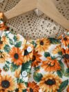 Baby girl wearing an adorable sunflower floral print dress perfect for summer