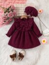 Adorable baby girl wearing a charming corduroy dress perfect for playtime or special occasions