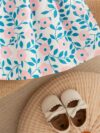 Adorable girl wearing a beautiful floral print summer dress perfect for a beach party