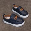 Close up of stylish brown leather boys loafers showcasing the stitching and buckle detail