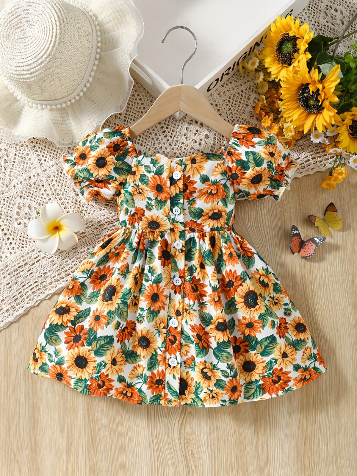 Baby girl wearing an adorable sunflower floral print dress perfect for summer