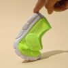 Adorable toddler wearing Newnesss Summer Breeze Sneakers running playfully outdoors on a sunny day