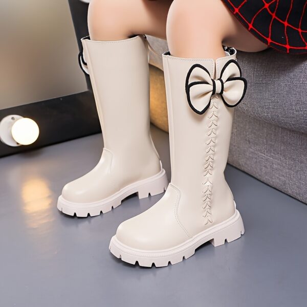 Stylish and warm girls fleece lined bow snow boots perfect for winter adventures The boots are shown from an angle showcasing the fleece lining the bow detail and the durable sole