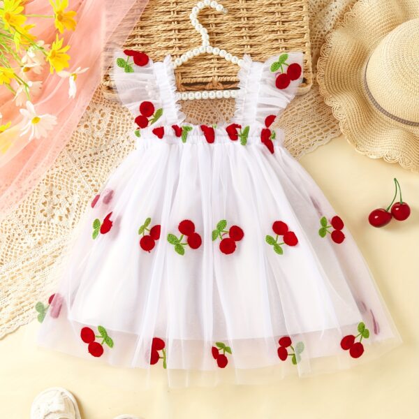 Adorable girl wearing a cherry print summer dress perfect for picnics and beach days
