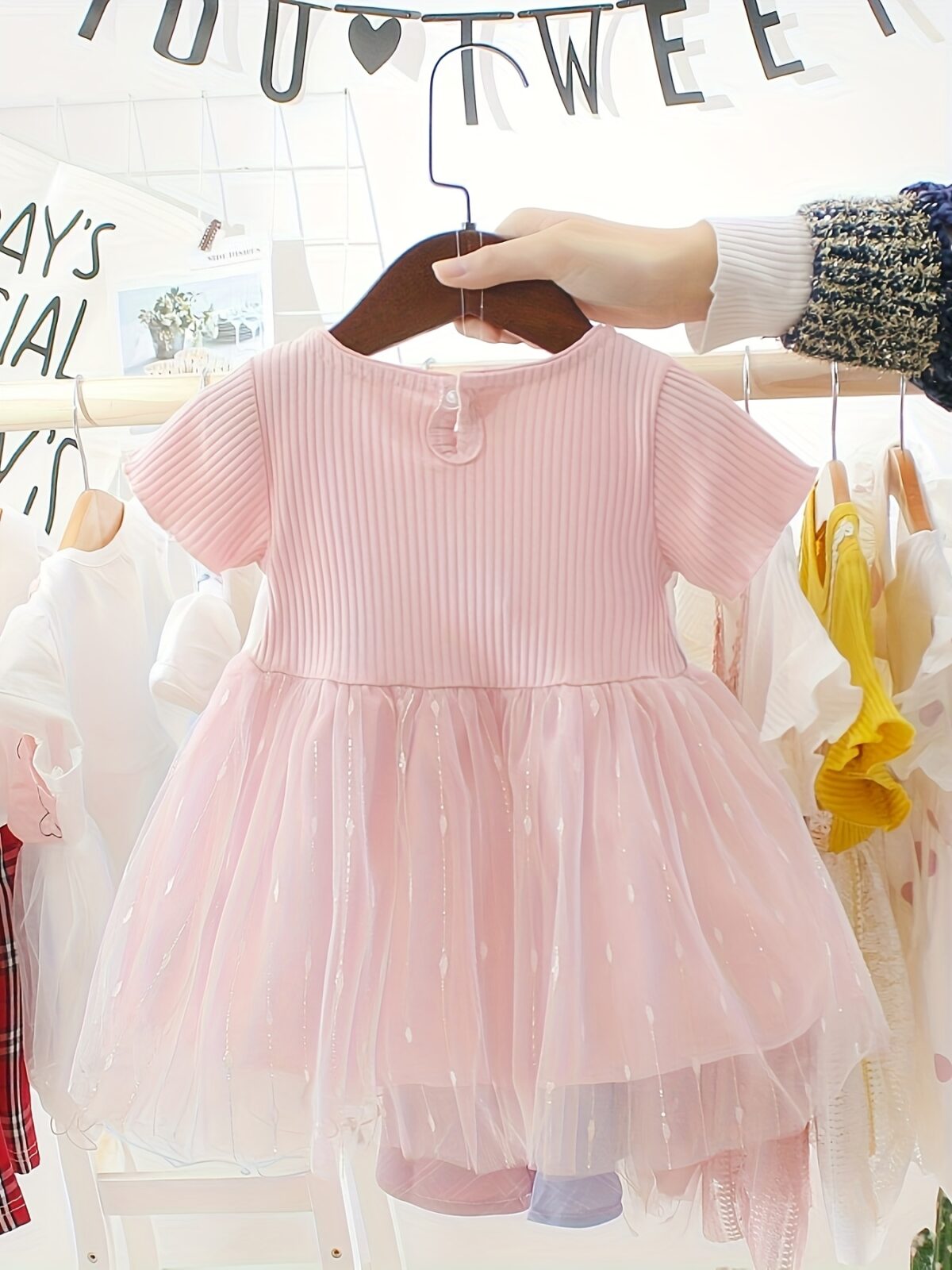 Adorable little girl twirling in a pink Summer Bloom Rose Princess Dress from Newness showcasing its comfortable and stylish design