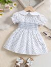 Adorable little girl twirling in a charming summer polka dot dress perfect for birthdays and special occasions