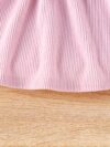 Adorable baby girl wearing a cozy corduroy dress set in fall colors perfect for autumn and winter The outfit includes a dress and matching pants
