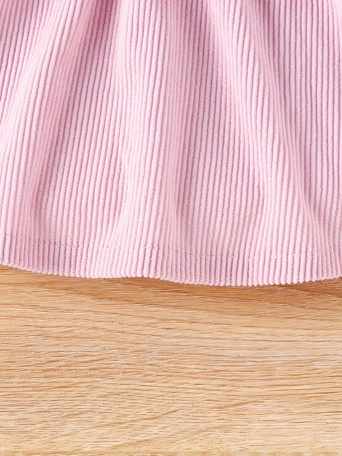 Adorable baby girl wearing a cozy corduroy dress set in fall colors perfect for autumn and winter The outfit includes a dress and matching pants