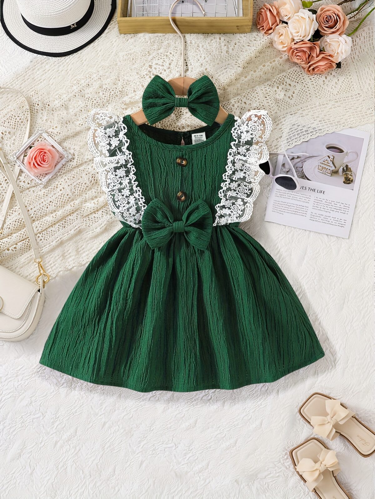 A baby girl wearing a charming summer garden themed dress smiling