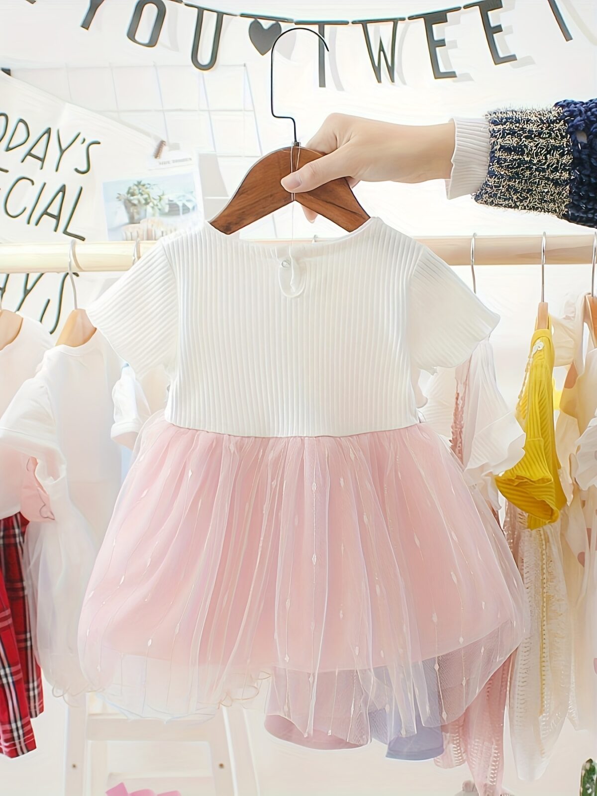 Adorable little girl twirling in a pink Summer Bloom Rose Princess Dress from Newness showcasing its comfortable and stylish design