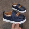 Close up of stylish brown leather boys loafers showcasing the stitching and buckle detail