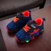 Boy wearing stylish Marvel Spider Man LED light up sneakers running and playing The sneakers light up showcasing vibrant colors