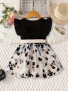 Adorable little girl twirling in a vibrant Summer Bloom floral print dress from Newness perfect for summer