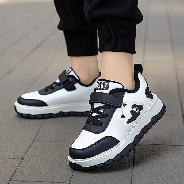 Adorable child wearing Newness Cozy Panda Kids Fleece Sneakers playing outdoors in the snow The sneakers are soft warm and feature a playful panda design