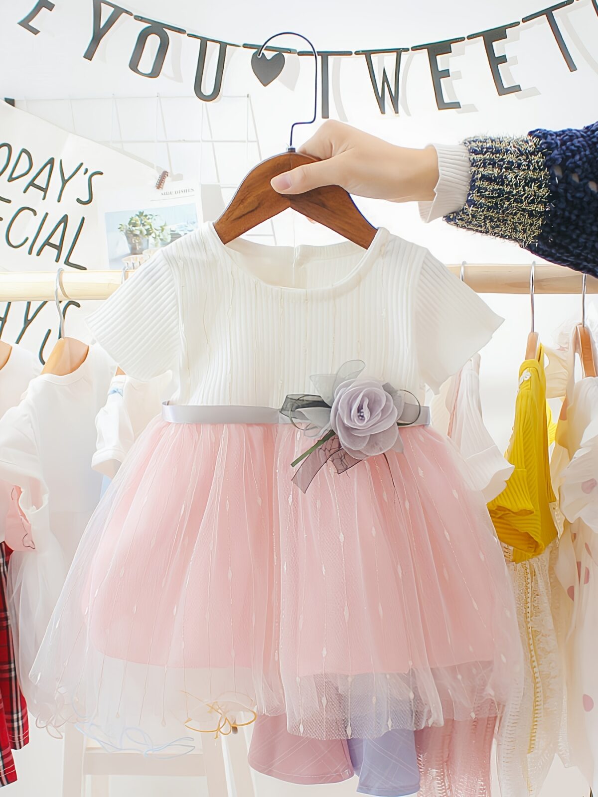 Adorable little girl twirling in a pink Summer Bloom Rose Princess Dress from Newness showcasing its comfortable and stylish design