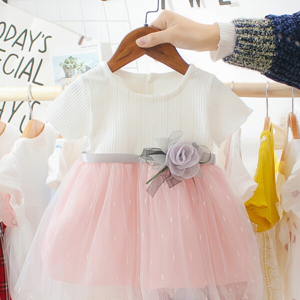 Adorable little girl twirling in a pink Summer Bloom Rose Princess Dress from Newness showcasing its comfortable and stylish design