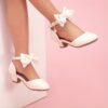 Enchanted Bow Girls White Heels by Newness Stylish and comfortable white heels with a charming bow detail perfect for any occasion