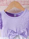 Adorable baby girl wearing a charming butterfly print dress from Newness perfect for spring and summer