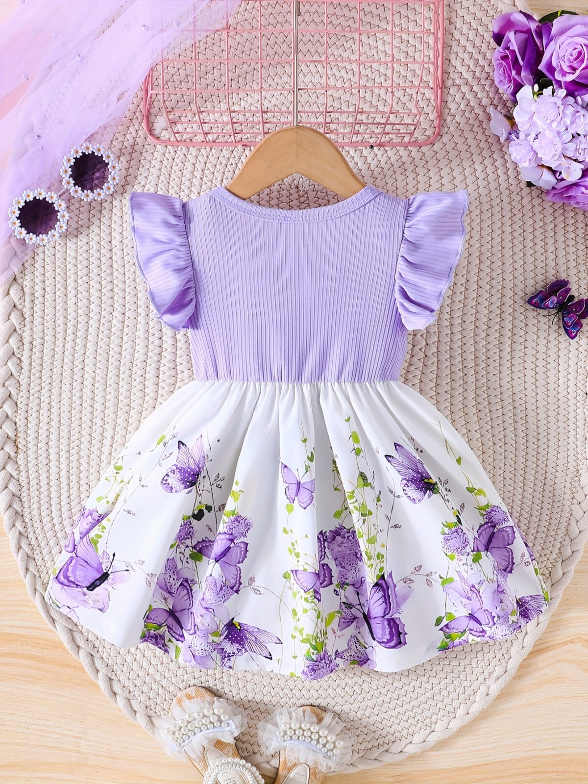 Adorable baby girl wearing a charming butterfly print dress from Newness perfect for spring and summer