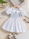 Adorable little girl twirling in a charming summer polka dot dress perfect for birthdays and special occasions