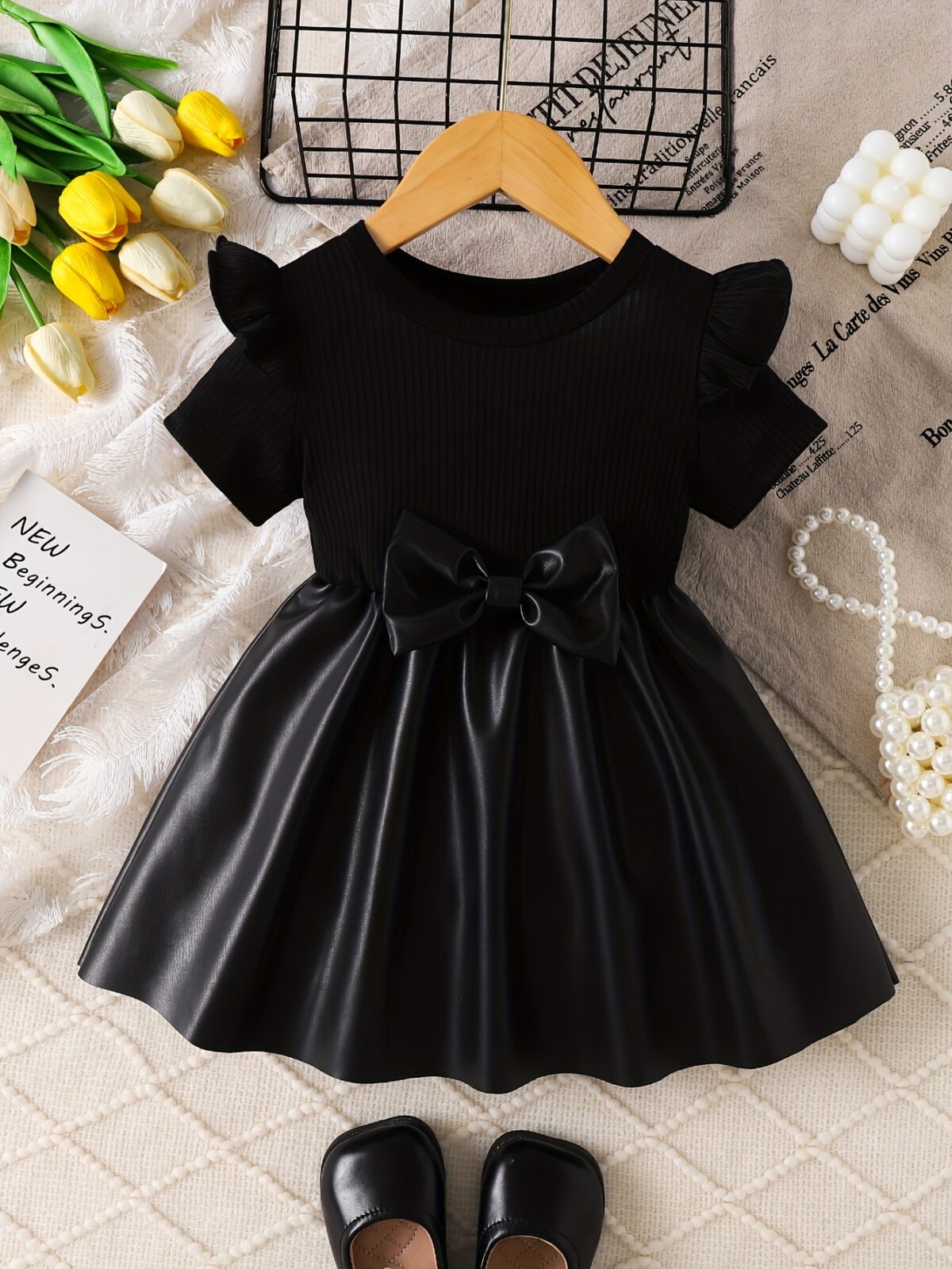 Adorable baby girl wearing a charming Little Darling Baby Bow Dress perfect for parties or playdates The dress features a beautiful bow detail