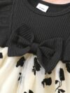Petite Fleur A charming girl in a floral mesh dress twirling happily