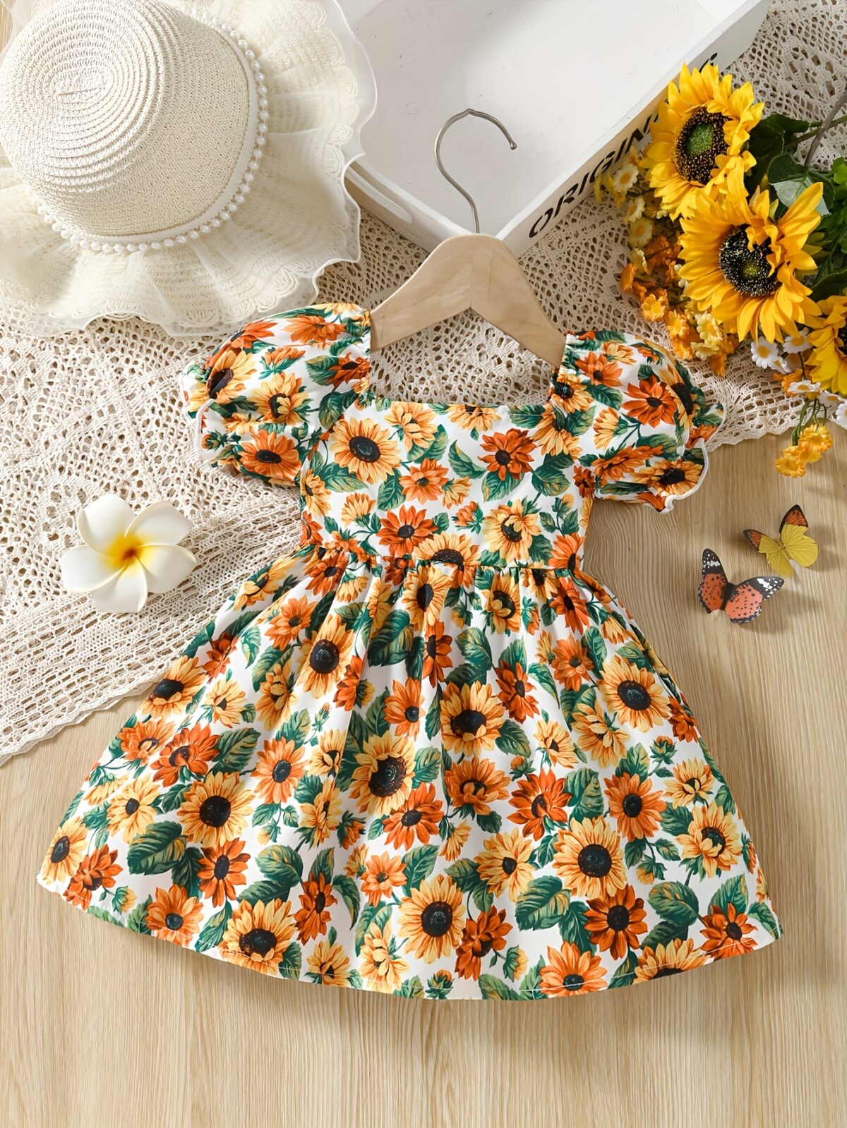 Baby girl wearing an adorable sunflower floral print dress perfect for summer
