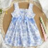 Model wearing a charming Provence Summer Bow Dress in a field of flowers The dress features a flattering silhouette and a cute bow