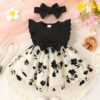 Petite Fleur A charming girl in a floral mesh dress twirling happily