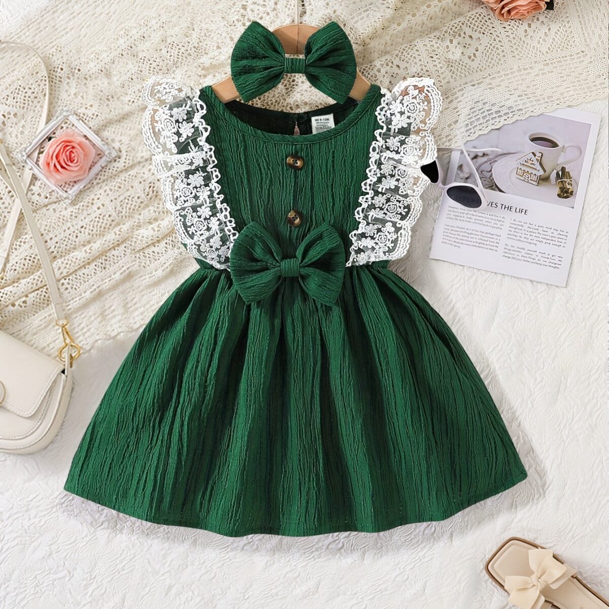A baby girl wearing a charming summer garden themed dress smiling