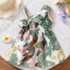 Baby girl wearing adorable Island Bloom floral print dress smiling