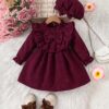 Adorable baby girl wearing a charming corduroy dress perfect for playtime or special occasions